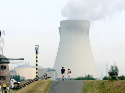A couple walks toward the cooling towers of a nuclear power plant in Doel, Belgium, Thursday Aug, 7, 2003. With a sweltering heat wave continuing to blanket much of Europe, many nuclear power plants have had to consider reducing their production due to high temperatures on the cooling towers. (AP Photo/Virginia Mayo)