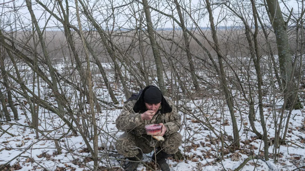 A Ukrainian army soldier from the 43rd Heavy Artillery Brigade eats, amid Russia's attack on Ukraine, near Bahmut, in Donetsk region, Ukraine, February 5, 2023. REUTERS/Marko Djurica   TPX IMAGES OF THE DAY