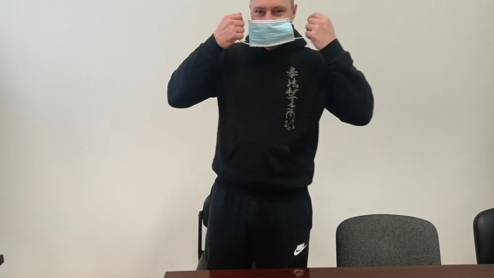 Običajno v srajco in kravato Žarko Gorenjc se je včeraj na sodi&scaron;ču pojavil v črni trenerki. Obraz si je pred fotografskim objektivom zakril z medicinsko masko. 