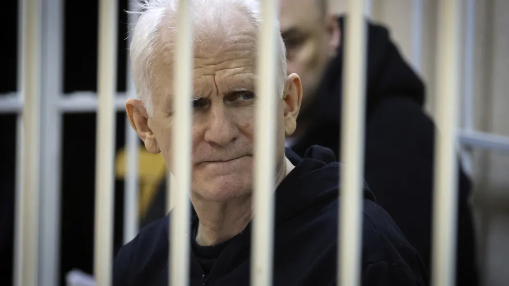 FILE - Ales Bialiatski, the head of Belarusian Vyasna rights group, sits in a defendants' cage during a court session in Minsk, Belarus, on Thursday Jan. 5, 2023. A Belarusian court has sentenced Ales Bialiatski, Belarus' top human rights advocate and one of the winners of the 2022 Nobel Peace Prize, to 10 years in prison. Bialiatski and three other top figures of the Viasna human rights center he founded were convicted of financing anti-government protests. (Vitaly Pivovarchyk/BelTA Pool Photo via AP, File)
