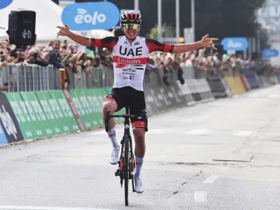 Tadej Pogacar celebrates as he crosses the finish line to win Il Lombardia cycling race from Bergamo to Como, Italy, Saturday, Oct. 8, 2022. (Gian Mattia D'Alberto/LaPresse via AP)