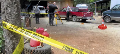 Investigators comb a property outside Wilderville, Ore., on Saturday, May 30, 2015, the morning after Oregon State Police troopers shot Robert Box. A lawsuit over the death of Box, who was killed by Oregon State Police outside his home near Wilderville in 2015 has been settled for .6 million after a lengthy legal odyssey, lawyers for the man's family said. The settlement includes an apology from OSP Superintendent Casey Codding, according to the lawyers for Box, who was 55 years old when he was slain by two state troopers investigating a domestic disturbance at his home. (Jeff Duewel/Grants Pass Daily Courier via AP)