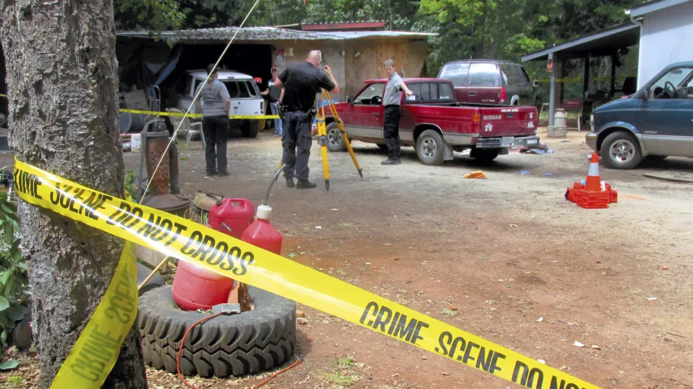 Investigators comb a property outside Wilderville, Ore., on Saturday, May 30, 2015, the morning after Oregon State Police troopers shot Robert Box. A lawsuit over the death of Box, who was killed by Oregon State Police outside his home near Wilderville in 2015 has been settled for $1.6 million after a lengthy legal odyssey, lawyers for the man's family said. The settlement includes an apology from OSP Superintendent Casey Codding, according to the lawyers for Box, who was 55 years old when he was slain by two state troopers investigating a domestic disturbance at his home. (Jeff Duewel/Grants Pass Daily Courier via AP)