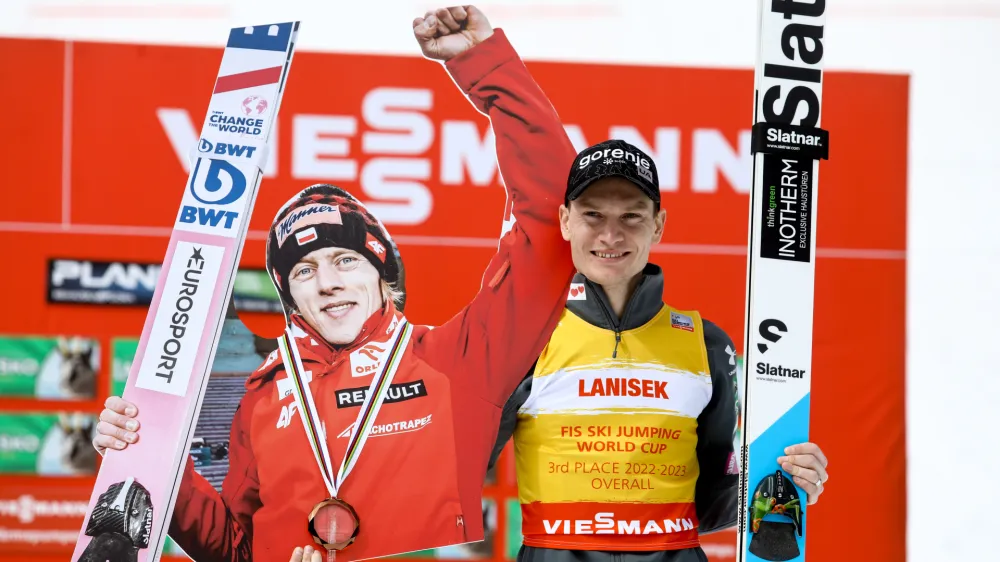 Anže Lani&scaron;ek je na zmagovalni oder v skupnem se&scaron;tevku svetovnega pokala pri&scaron;el s kartonskim portretom Dawida Kubackega, ki se zaradi težav z ženinim zdravjem na koncu sezone ni boril za skupno drugo in tretje mesto. Foto: Luka Cjuha