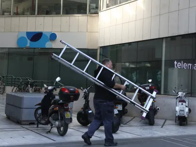  mobilni operater Telemach in Telekom &ndash; delavec, lestev, telefoniranje <br><br>- 23.09.2022 - plo&scaron;čad Trg Ajdov&scaron;čina pri Metalki v Ljubljani <br> <br>//FOTO: Luka Cjuha