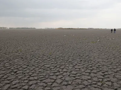 People walk on dried up Lake Zicksee near Sankt Andrae, Austria, April 9, 2023. REUTERS/Leonhard Foeger