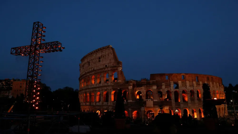 A cross is lit up for the Via Crucis (Way of the Cross) procession, which Pope Francis is to follow from Casa Santa Marta at the Vatican due to the intense cold, as part of Good Friday celebrations at the Colosseum, in Rome, Italy April 7, 2023. REUTERS/Remo Casilli
