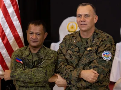 Philippines Exercise Director Major General Marvin Licudine links arms with U.S. Exercise Director representative Major General Eric Austin after the news conference on the opening ceremony of the annual Philippines-U.S. joint military exercises or Balikatan, at the Armed Forces of the Philippines headquarters, in Quezon City, Metro Manila, Philippines, April 11, 2023. REUTERS/Eloisa Lopez