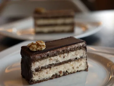 - Maxi rezina / Emonska rezina -<br><br>- 13.04.2023 - Kavarna In Sla&scaron;čičarna Maxi v Ljubljani že pol stoletja slovi po svoji orehovi Maxi rezini, ki jo je priznani sla&scaron;čičarski mojster Avgust Plestenjak pred tem pripravljal za angle&scaron;ko kraljevo družino na &scaron;kotskem dvorcu Balmoral. <br><br><br>//FOTO: Tomaž Skale<br>