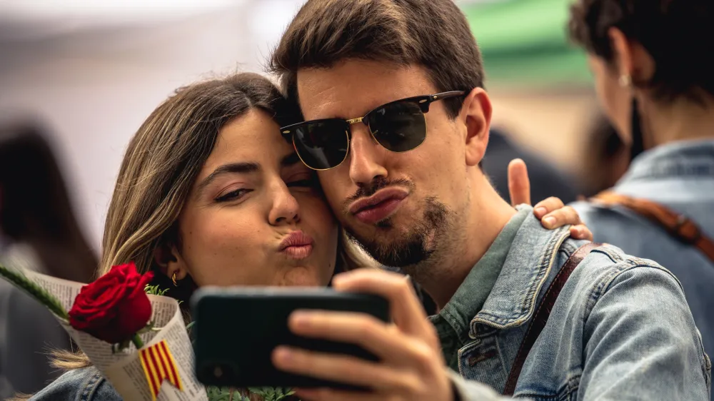 23 April 2023, Spain, Barcelona: A couple takes a 'selfie' on St George's Day, Catalonia's patron saint, celebrated in a Valentine's Day fashion as it also coincided with what is popularly known as the Day of the Rose and the Day of the Book. Photo: Matthias Oesterle/ZUMA Press Wire/dpa
