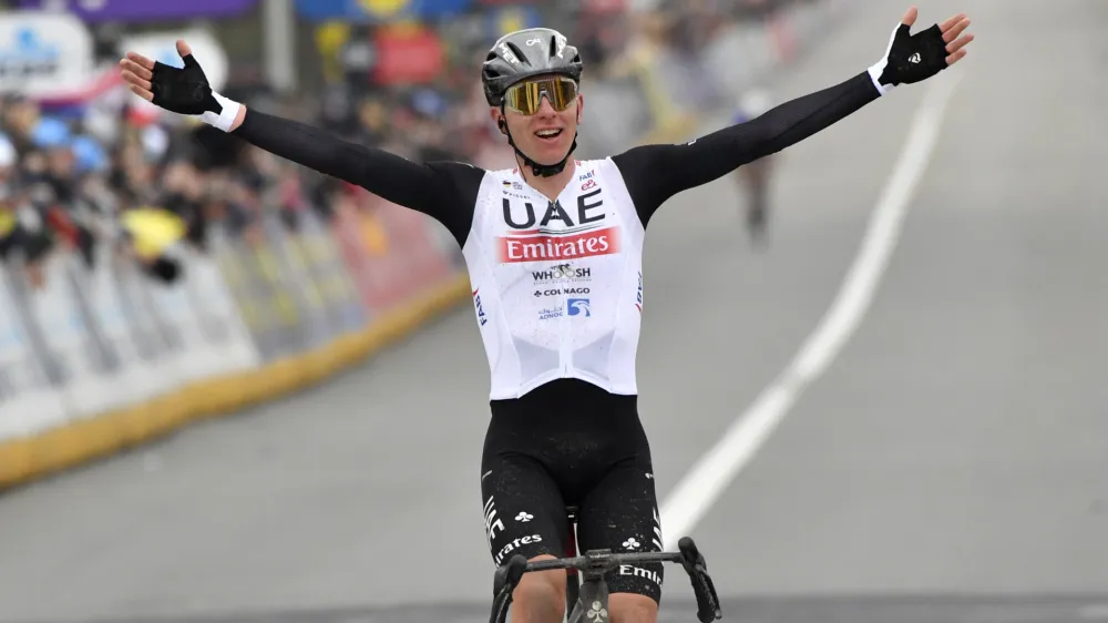 Slovenia's Tadej Pogacar of the UAE Team Emirates celebrates as he crosses the finish line to win the Tour of Flanders in Oudenaarde, Belgium on Sunday, April 2, 2023. (AP Photo/Geert Vanden Wijngaert)