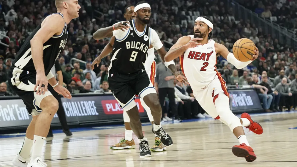 Miami Heat's Gabe Vincent (2) drives to the basket against Milwaukee Bucks' Bobby Portis (9) and Brook Lopez during the first half of Game 2 of an NBA basketball first-round playoff series Wednesday, April 19, 2023, in Milwaukee. (AP Photo/Aaron Gash)