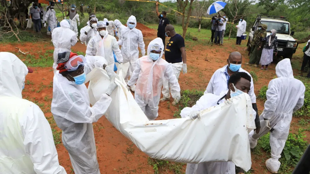 Forensic experts and homicide detectives carry the bodies of suspected members of a Christian cult named as Good News International Church, who believed they would go to heaven if they starved themselves to death, after their remains were exhumed from their graves in Shakahola forest of Kilifi county, Kenya April 22, 2023. REUTERS/Stringer