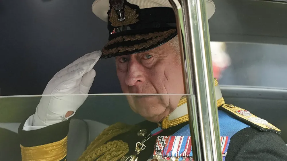FILE - King Charles III salutes as he leaves Westminster Abbey following the state funeral service of Queen Elizabeth II in Westminster Abbey in central London, England, Monday Sept. 19, 2022.After waiting 74 years to become king, Charles has used his first six months on the throne to meet faith leaders across the country, reshuffle royal residences and stage his first overseas state visit. With the coronation just weeks away, Charles and the Buckingham Palace machine are working at top speed to show the new king at work. (AP Photo/Martin Meissner, File)