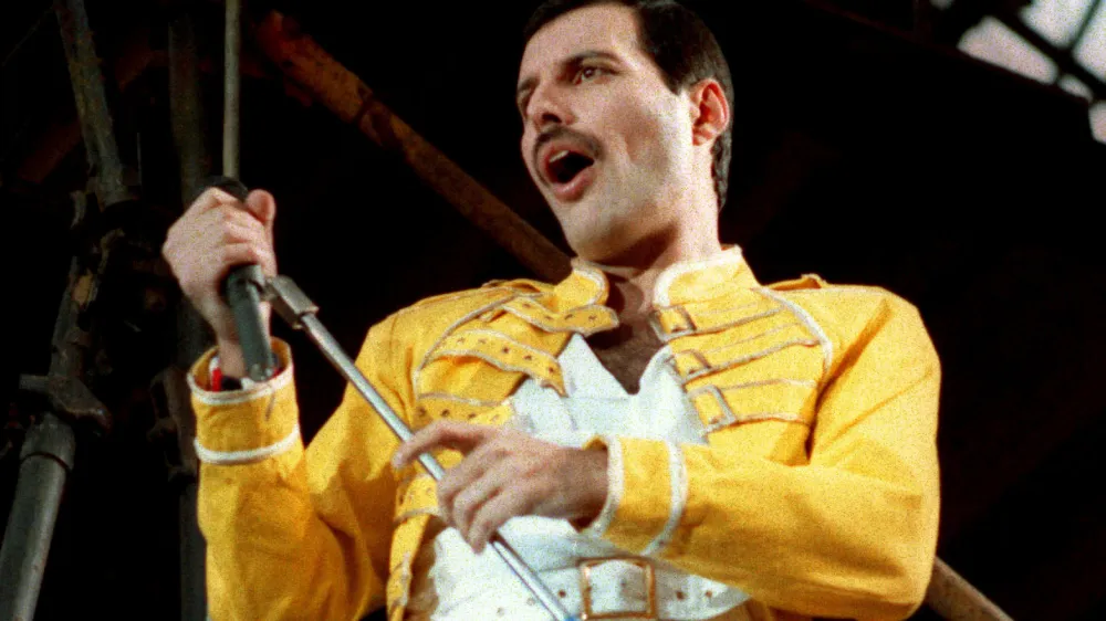 FILE - Queen lead singer Freddie Mercury performs, in Cologne, Germany, on Sunday, July 20, 1986 file photo. Freddie Mercury's extensive collection of costumes, fine art, and even handwritten working lyrics to "We Are the Champions" will be auctioned in Sept. 2023. (AP Photo/Marco Arndt, File)