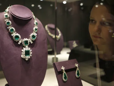 An employee looks at 'The Bvlgari Emerald Suite' on display during a press preview at Christie's London, Friday, Sept. 23, 2011. The suite includes a necklace estimated to reach 975,000 British pounds US .5 million, a pendant 450,000 British pounds US $ 700,000, a ring 520,000 British pounds US 0,000, a bracelet 325,000 British pounds US 0,000 and earrings 130,000 British pounds US 0,000. They go on sale as part of the Collection of Elizabeth Taylor at Christie's New York in December. (AP Photo/Akira Suemori)