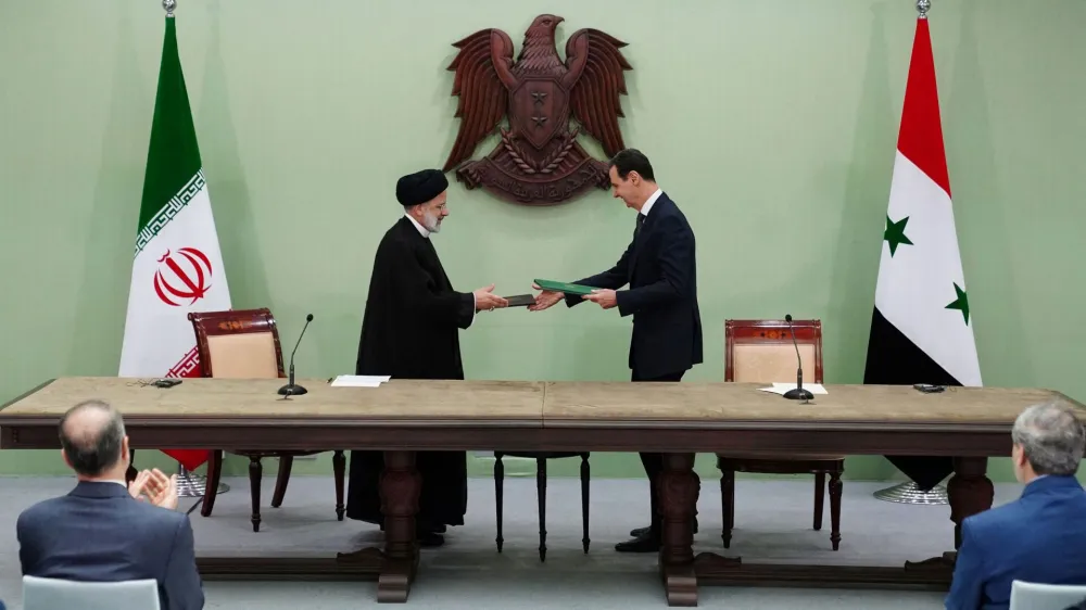 Syria's President Bashar al-Assad and Iranian President Ebrahim Raisi are pictured during the signing of cooperation agreement in Damascus, Syria, in this handout released by SANA on May 3, 2023. SANA/Handout via REUTERS ATTENTION EDITORS - THIS IMAGE WAS PROVIDED BY A THIRD PARTY.
