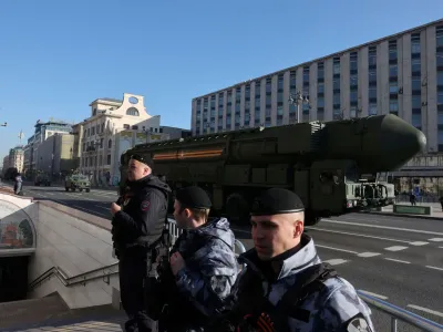 Law enforcement officers stand guard as Russian Yars intercontinental ballistic missile systems and other armoured vehicles drive along a street before a military parade on Victory Day, which marks the 78th anniversary of the victory over Nazi Germany in World War Two, in Moscow, Russia May 9, 2023. REUTERS/Yulia Morozova