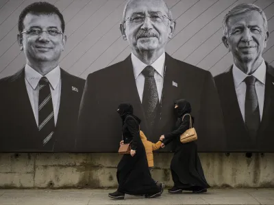 People walk past an election campaign billboard of Republican People's Party presidential candidate Kemal Kilicdaroglu, center, Istanbul Mayor Ekrem Imamoglu, left, and Ankara Mayor Mansur Yavas ahead of the May 14 presidential and parliamentary elections, in Istanbul, Turkey, Saturday, May 6, 2023. (AP Photo/Emrah Gurel)