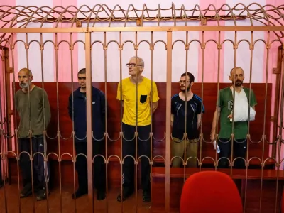 Foreign nationals Vjekoslav Prebeg from Croatia, Dylan Healy from Britain, John Harding from Britain, Mathias Gustafsson from Sweden and Andrew Hill from Britain, who were captured by pro-Russian forces while allegedly fighting for Ukrainian troops during Ukraine-Russia conflict, stand inside a defendants' cage during a court hearing in Donetsk, Ukraine August 15, 2022. REUTERS/Alexander Ermochenko