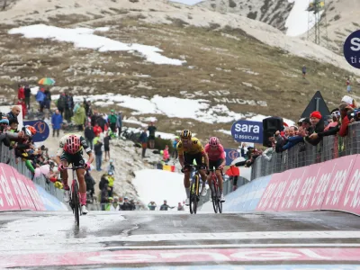 Primož Roglič (v sredini) je tik pred ciljno črto dana&scaron;nje etape ukradel tri sekunde nosilcu rožnate majice, Valižanu Geraintu Thomasu (desno).