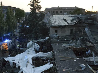 In this photo provided by the National Police of Ukraine, people clear the rubble in a restaurant RIA Pizza destroyed by a Russian attack in Kramatorsk, Ukraine, Tuesday, June 27, 2023. (National Police of Ukraine via AP)