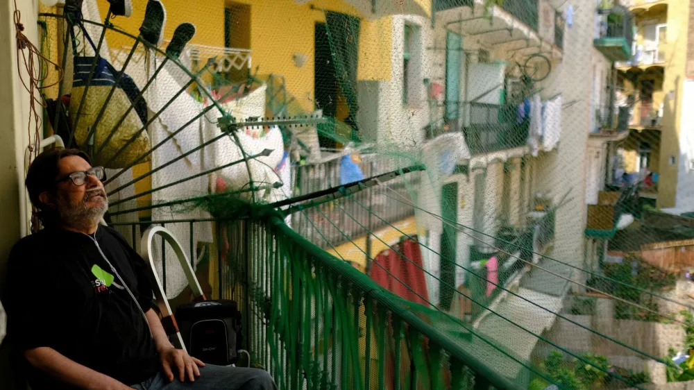 Fernando Uceta, 62, who suffers from COPD, following a double lung transplant in August 2022, uses a portable oxygen concentrator backpack with a battery to breathe as he sits in the balcony of his house before going to the Hospital del Mar for a check-up with his doctor, during the first summer heatwave, in Barcelona's Raval neighbourhood, Spain June 27, 2023. REUTERS/Nacho Doce