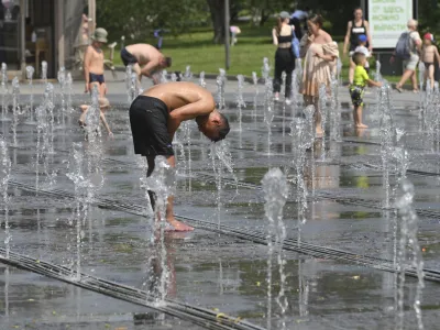 People cool off in a fountain in Moscow, Russia, Thursday, July 6, 2023. The temperatures in Moscow are over 30 Celsius (86 Fahrenheit). (AP Photo/Dmitry Serebryakov)