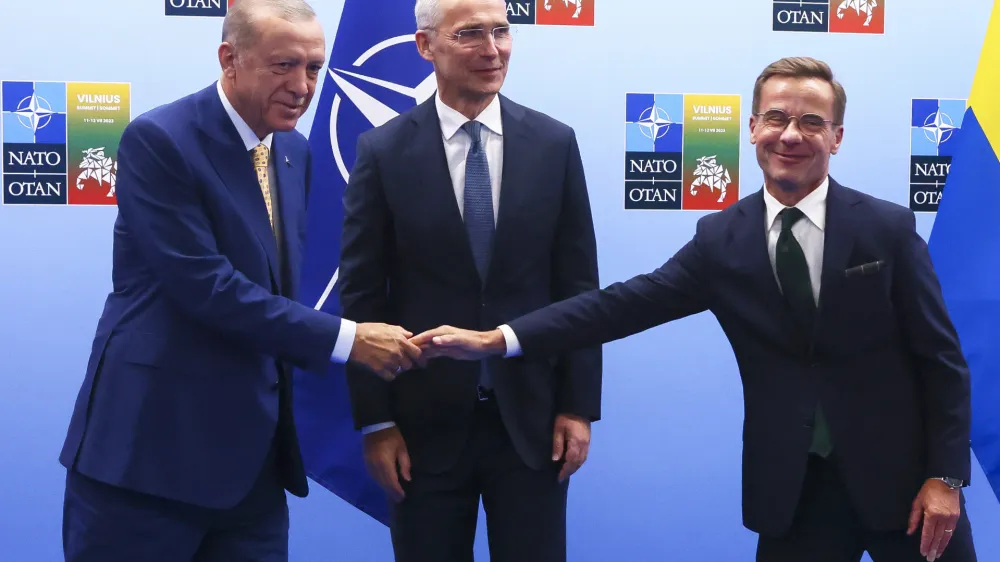 Turkey's President Recep Tayyip Erdogan, left, shakes hands with Sweden's Prime Minister Ulf Kristersson, right, as NATO Secretary General Jens Stoltenberg looks on prior to a meeting ahead of a NATO summit in Vilnius, Lithuania, Monday, July 10, 2023. (Yves Herman, Pool Photo via AP)