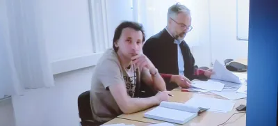 Zaradi pomanjkanja paznikov Grintala tudi tokrat niso mogli pripeljati iz ljubljanskih priporov. Zato je obravnavo spremljal preko videopovezave. Ob njem zagovornik Matjaž Medle.