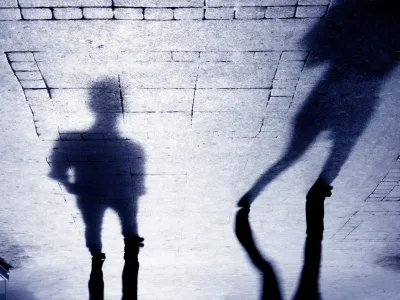 Upside down shadow of two person on pattered sidewalk, in black and white