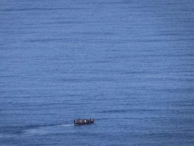 PRODUCTION - 29 June 2023, Italy, Lampedusa: Migrants steer a boat from the northern coast of Africa across the Mediterranean Sea towards the Italian island of Lampedusa. More and more African refugees are crossing to Italy from Tunisia. Many migrants pay a high price for the journey, not only financially. Photo: Oliver Weiken/dpa