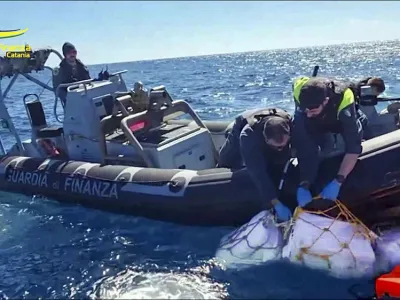 Boxes containing cocaine are taken on board in the Sicilian Strait off Catania in this picture made available by the Italian Financial Police on Monday, April 17, 2023. Some two thousand kilograms of cocaine, left afloat in open waters with a tracking device attached, were sized by the Italian Financial Police on Monday. (Italian Financial Police via AP)