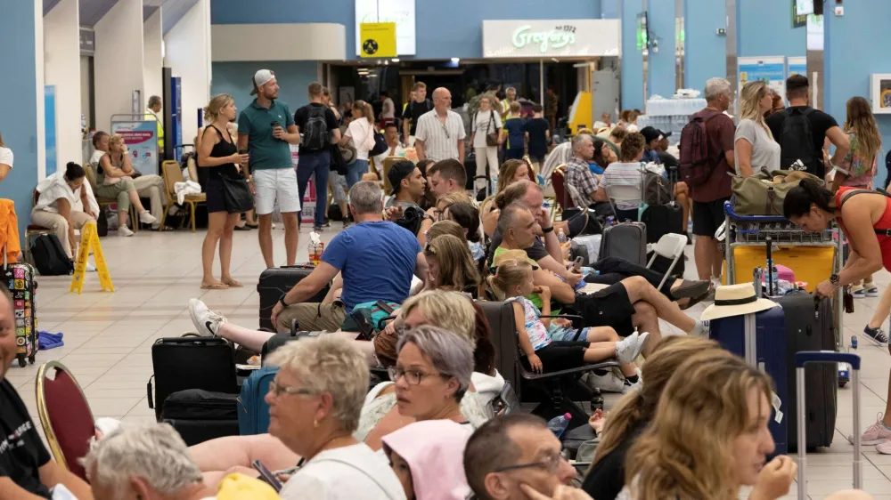 Tourists wait for departing planes at the airport, after being evacuated following a wildfire on the island of Rhodes, Greece, July 24, 2023. REUTERS/Nicolas Economou