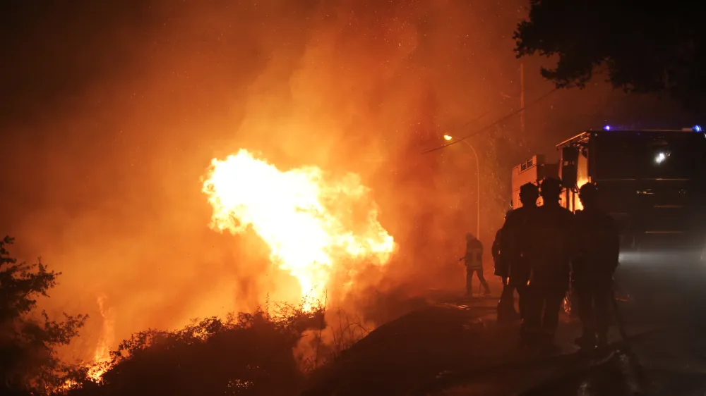 Firefighters spray water as they try to douse a fire near the village of Biguglia, Corsica island, France, Tuesday, July 25, 2017. Hundreds of firefighters are battling blazes fanned by high winds in more than a dozen zones in the Riviera region of southern France. (AP Photo/Raphael Poletti)
