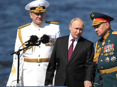 HANDOUT - 30 July 2023, Russia, Saint Petersburg: Russian President Vladimir Putin (C)&nbsp;stands with Russian Defence Minister Sergei Shoigu (R)&nbsp;and Russian Navy Admiral Nikolai Yevmenov during the Naval&nbsp;Parade marking the Russian Navy Day. Photo: -/Kremlin/dpa - ATTENTION: editorial use only and only if the credit mentioned above is referenced in full