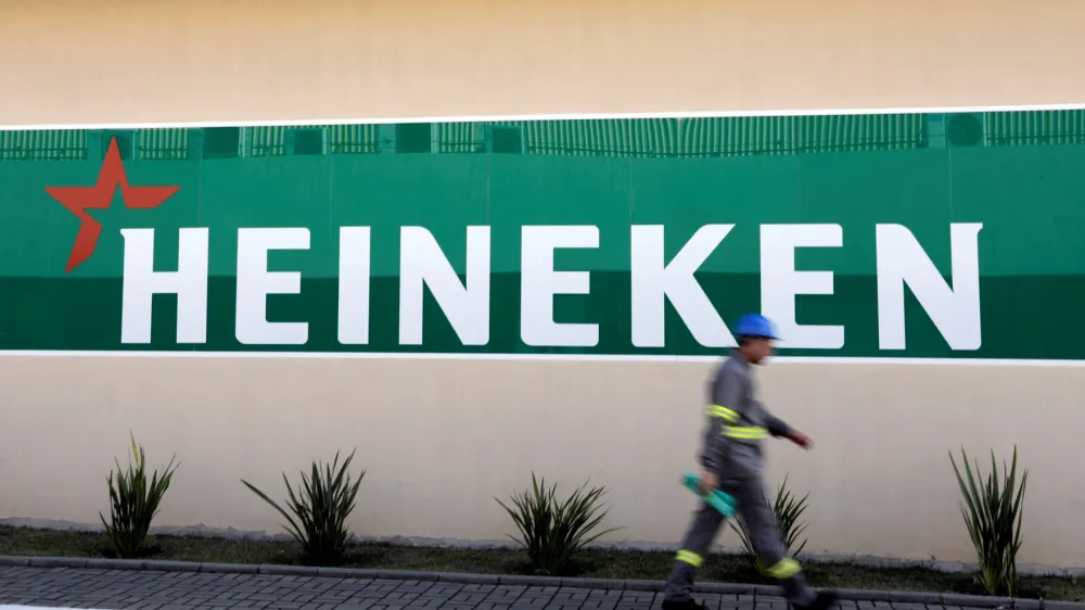 FILE PHOTO: An employee walks past the logo of Heineken at the Heineken brewery in Jacarei, Brazil June 12, 2018. REUTERS/Paulo Whitaker/File Photo