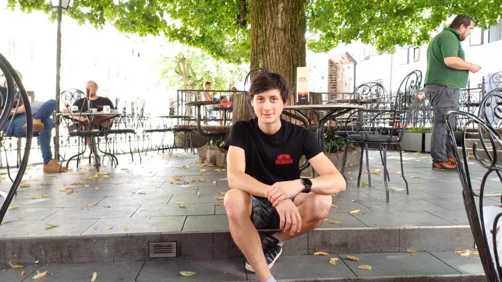 Cene Prevc pod mogočno Homanovo lipo, za&scaron;čitnim znakom kavarne in sla&scaron;čičarne na &scaron;kofjelo&scaron;kem Mestnem trgu.