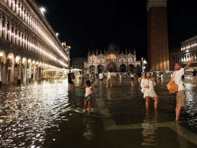 Tourists walk through flooded St Mark's Square after unusually high water levels in Venice, Italy, August 1, 2023. REUTERS/Manuel Silvestri