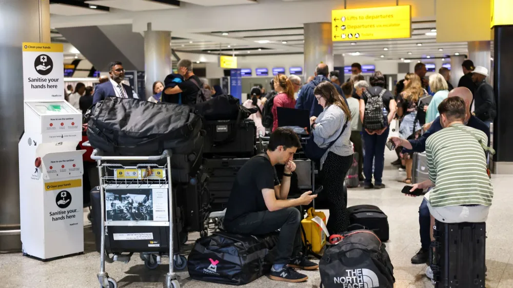 Travellers wait near the British Airways check-in area at Heathrow Airport, as Britain's National Air Traffic Service (NATS) restricts UK air traffic due to a technical issue causing delays, in London, Britain, August 28, 2023. REUTERS/Hollie Adams