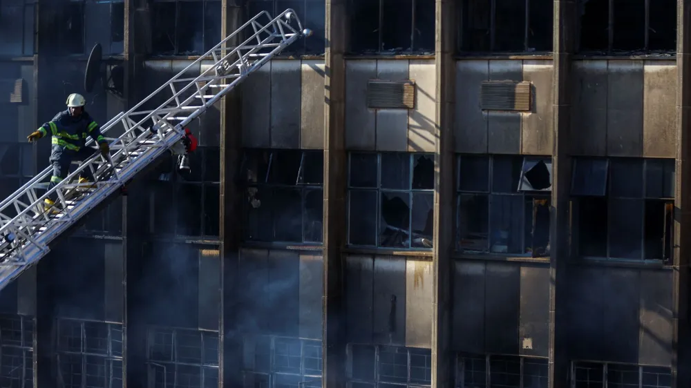 A firefighter works at the scene of a deadly blaze, in Johannesburg, South Africa August 31, 2023. REUTERS/Siphiwe Sibeko