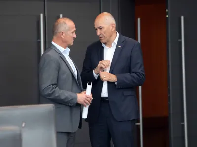 Janez Jan&scaron;a (desno) od države zahteva vrtoglavo visoko od&scaron;kodnino, državno odvetni&scaron;tvo pa mu ponuja precej manj; vendar &scaron;e vedno več kot povprečnemu obsojencu.&nbsp;