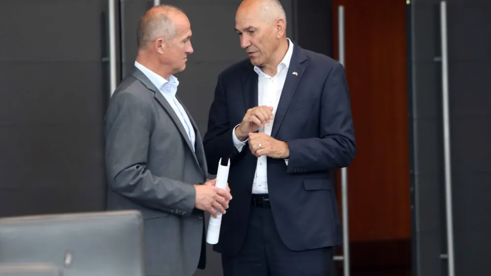 Janez Jan&scaron;a (desno) od države zahteva vrtoglavo visoko od&scaron;kodnino, državno odvetni&scaron;tvo pa mu ponuja precej manj; vendar &scaron;e vedno več kot povprečnemu obsojencu.&nbsp;