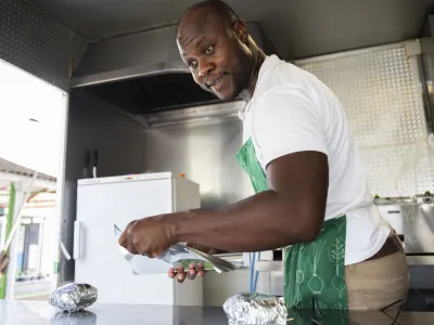 Kuhar in nutricionist Mike Dayo iz Nigerije, ki v Sloveniji živi že 17 let, v kulinaričnem tovornjaku pripravlja jedi iz zahodne Afrike.&nbsp;