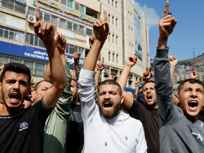 Palestinci na Zahodnem bregu protestirajo zaradi bombardiranja bolni&scaron;nice v Gazi, za kar obtožujejo Izrael, in nasploh zaradi razmer v palestinski enklavi. Protesti so sicer danes potekali po vsem svetu, od Tokia in Džakarte do Latinske Amerike. Foto: AP