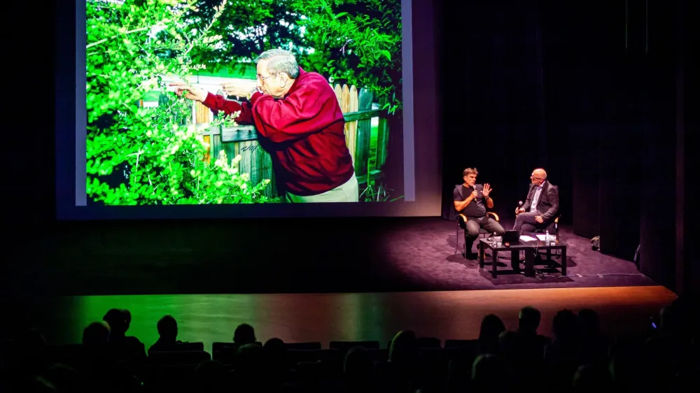 Ed Hoffman pred objektivom Arneta Hodaliča simulira, kako je videl drugega strelca. V desnem kotu v Linhartovi dvorani sta se o znameniti fotoreportaži pogovarjala Arne Hodalič (levo) in Ali Žerdin (desno).
