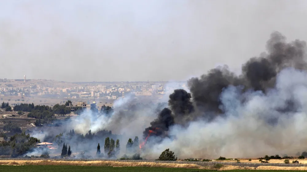 Smoke rises from a fire as a result of fighting in the the Syrian village of Quneitra near the border with Israel, as seen from an observatory near the Quneitra crossing, Thursday, June 6, 2013. Syrian rebels on Thursday captured a crossing point along a cease-fire line with Israel in the contested Golan Heights, a development that could deepen Israeli concerns over the growing role of Islamic radicals in the civil war near its northern frontier.(AP Photo/Sebastian Scheiner)