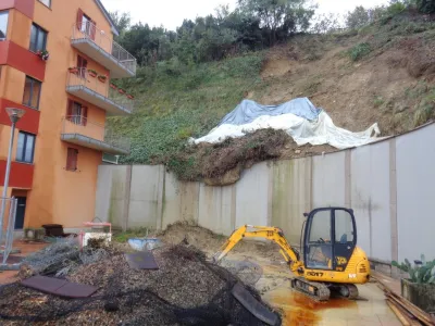 Delavci odstranjujejo približno 25 metrov dolgo plazino in utrjujejo brežino ob bloku.&nbsp;