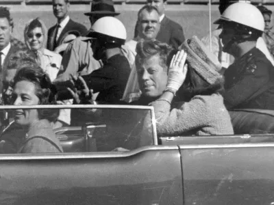 FILE - President John F. Kennedy waves from his car in a motorcade approximately one minute before he was shot, Nov. 22, 1963, in Dallas. Riding with President Kennedy are first lady Jacqueline Kennedy, right, Nellie Connally, second from left, and her husband, Texas Gov. John Connally, far left. The 60th anniversary of President Kennedy's assassination, marked on Wednesday, Nov. 22, 2023, finds his family, and the country, at a moment many would not have imagined in JFK's lifetime. (AP Photo/Jim Altgens, File)