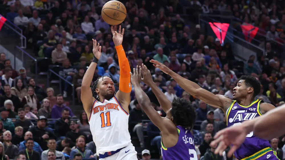 Dec 13, 2023; Salt Lake City, Utah, USA; New York Knicks guard Jalen Brunson (11) shoots the ball over Utah Jazz guard Collin Sexton (2) and guard Ochai Agbaji (30) during the second quarter at Delta Center. Mandatory Credit: Rob Gray-USA TODAY Sports